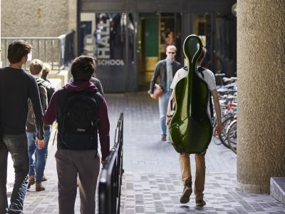 Students walk into Guildhall Silk Street building entrance on a sunny day